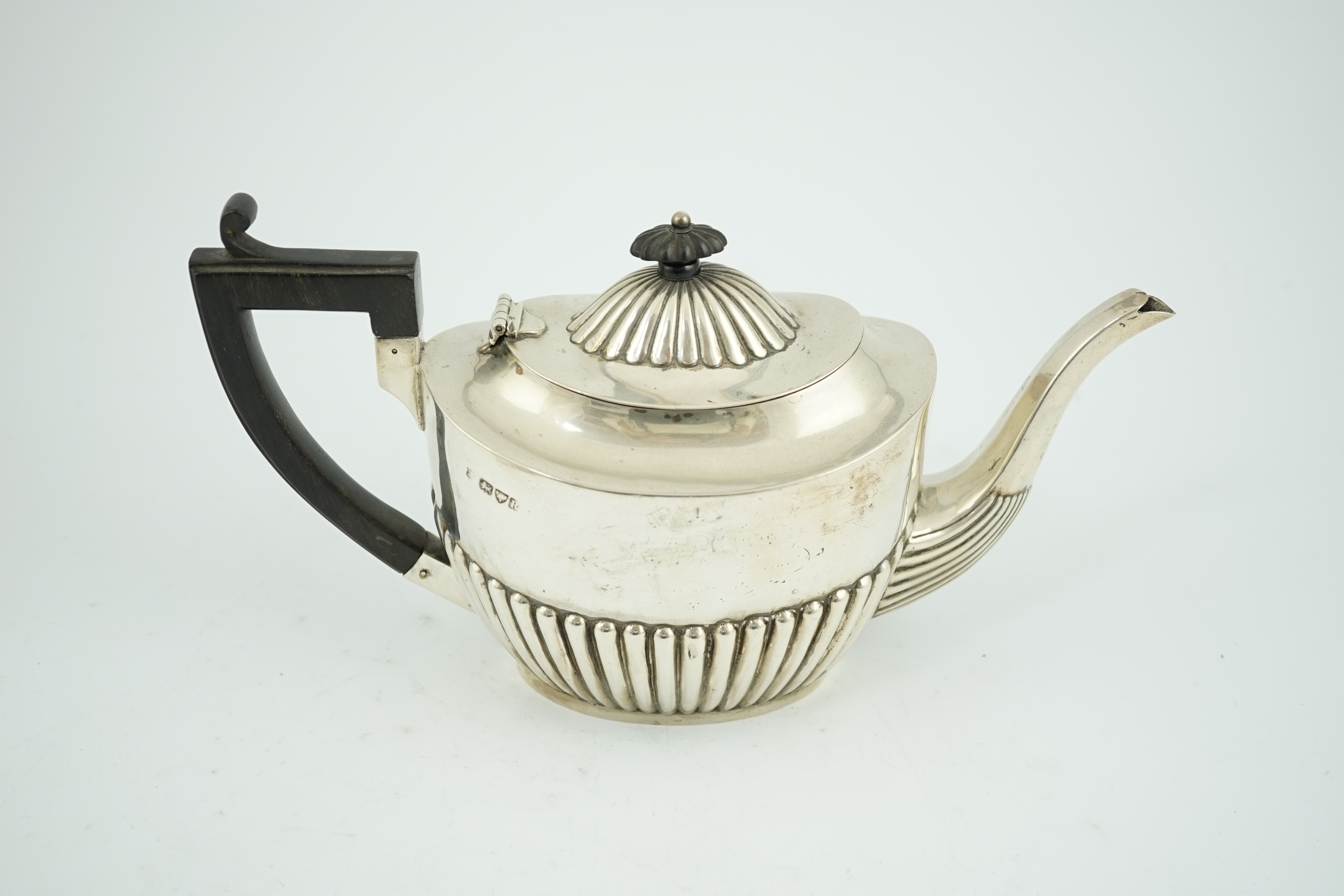 A late Victorian demi-fluted silver oval teapot, Nathan & Hayes, Chester, 1900, gross weight 17.1oz. Condition - fair.